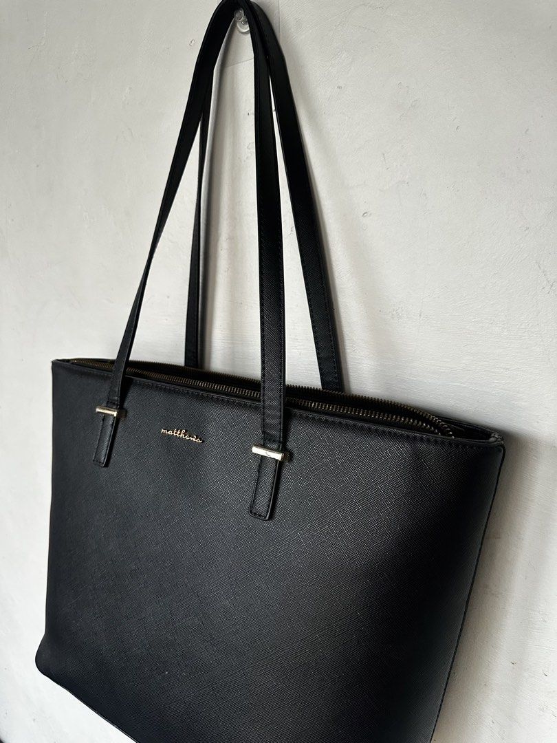 Matthews Black Leather Tote Bag (Category: Tote Bags) located in Manila. Submitted by omelette.12 (Listing ID 1470246821, Image 2). Description: - 1,799 original price, rfs: not using it anymore - Material: Premium Saffiano leather texture with chic gold lettering logo - Closure & Straps: Secure top zip closure with comfortable dual shoulder straps - Interior: Spacious compartment for all your daily essentials, laptop, or school items - Design: C