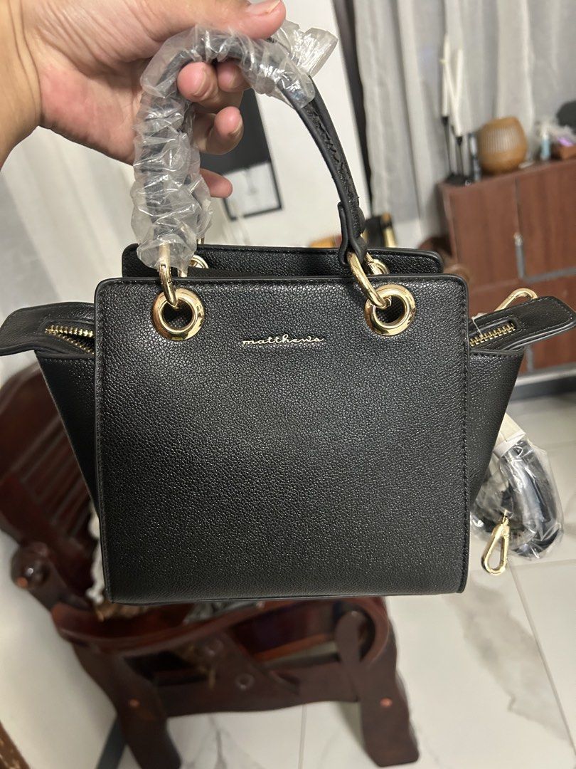 Matthews Black Luke Handbag Bag (Category: Luxury Bags & Wallets) located in Cavite. Submitted by florabells (Listing ID 1470273193, Image 1). Description: - Brand: Matthews (Model: Luke) - Color: Black with chic gold hardware - Material: Textured leather-look - Condition: Brand new, never used, straight from the store with original SM Store tag (₱1,999.00) - Features: Main zipper compartment with inner divider - Inclusions: Top handles (still wr