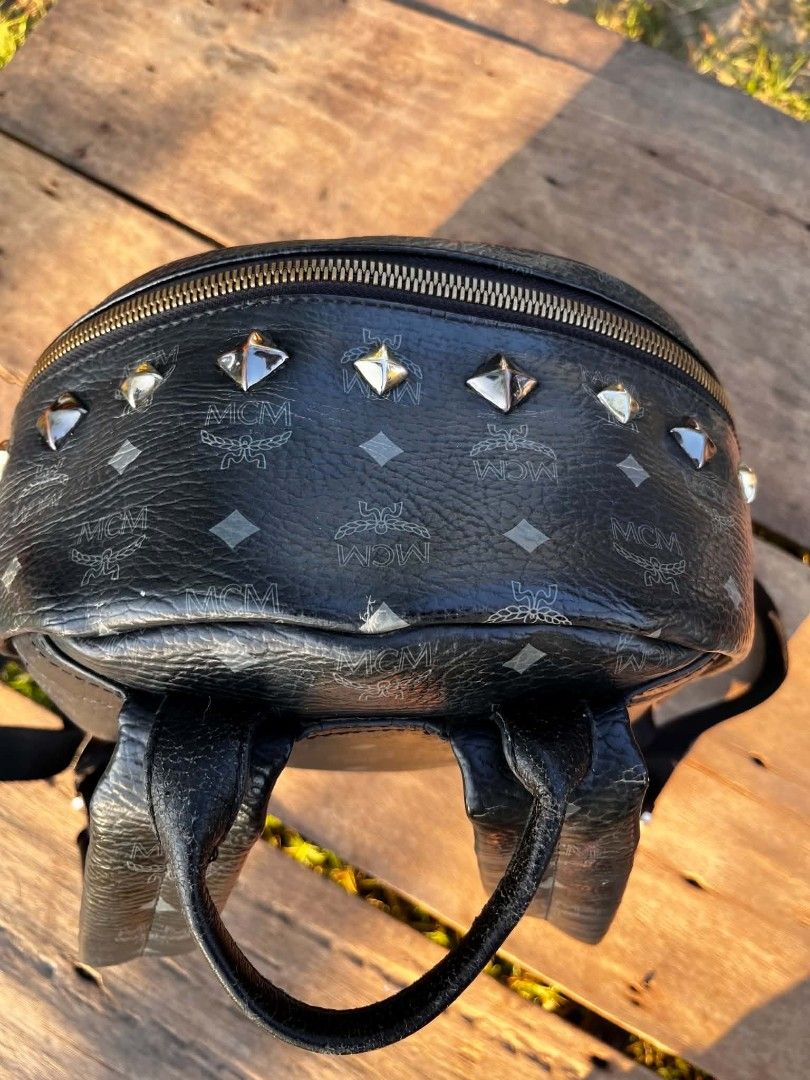 MCM Stark Visetos Studded Backpack Black (Category: Backpacks) located in Manila. Submitted by phil_thrift (Listing ID 1470165199, Image 3). Description: - black MCM monogram backpack - Edgy metallic stud details on the front pocket and corners - Spacious main compartment with secure zip closure - Convenient front zippered pocket for extra storage - Durable solid black leather trim - Comfortable adjustable shoulder straps and top handle - Perfect