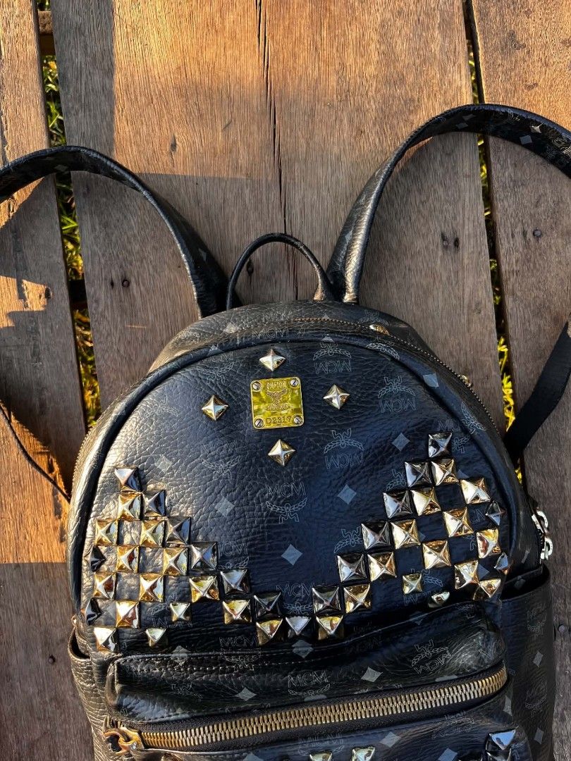 MCM Stark Visetos Studded Backpack Black (Category: Backpacks) located in Manila. Submitted by phil_thrift (Listing ID 1470165199, Image 2). Description: - black MCM monogram backpack - Edgy metallic stud details on the front pocket and corners - Spacious main compartment with secure zip closure - Convenient front zippered pocket for extra storage - Durable solid black leather trim - Comfortable adjustable shoulder straps and top handle - Perfect