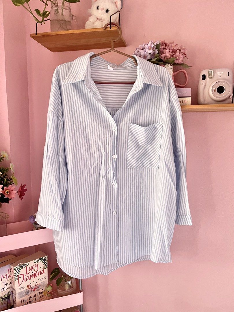 MEIPAIYIDING Blue White Striped Button Down Shirt (Category: Shirts) located in Imus. Submitted by muyingyingyinggg (Listing ID 1470236043, Image 1). Description: - Light blue and white vertical striped oversized shirt - Classic collar with front button closure - Single chest pocket and roll-up sleeves with button tabs - Lightweight, breathable fabric ideal for layering or solo wear - Condition: Excellent, no flaws found.