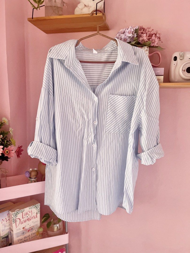 MEIPAIYIDING Blue White Striped Button Down Shirt (Category: Shirts) located in Imus. Submitted by muyingyingyinggg (Listing ID 1470236043, Image 2). Description: - Light blue and white vertical striped oversized shirt - Classic collar with front button closure - Single chest pocket and roll-up sleeves with button tabs - Lightweight, breathable fabric ideal for layering or solo wear - Condition: Excellent, no flaws found.