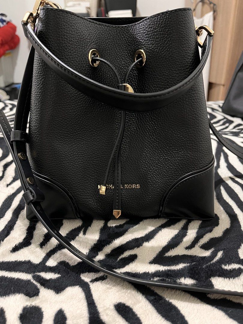 Michael Kors Black Leather Bucket Bag (Category: Luxury Bags & Wallets) located in Quezon City. Submitted by pickleballpaddle (Listing ID 1470327976, Image 1). Description: - Brand: Michael Kors - Material: Premium black pebbled leather - Hardware: Gold-tone with protective bottom feet - Closure: Secure drawstring top - Strap: Removable and adjustable shoulder strap - Interior: Clean lining with a convenient zippered pocket - Structure: Sturdy ba
