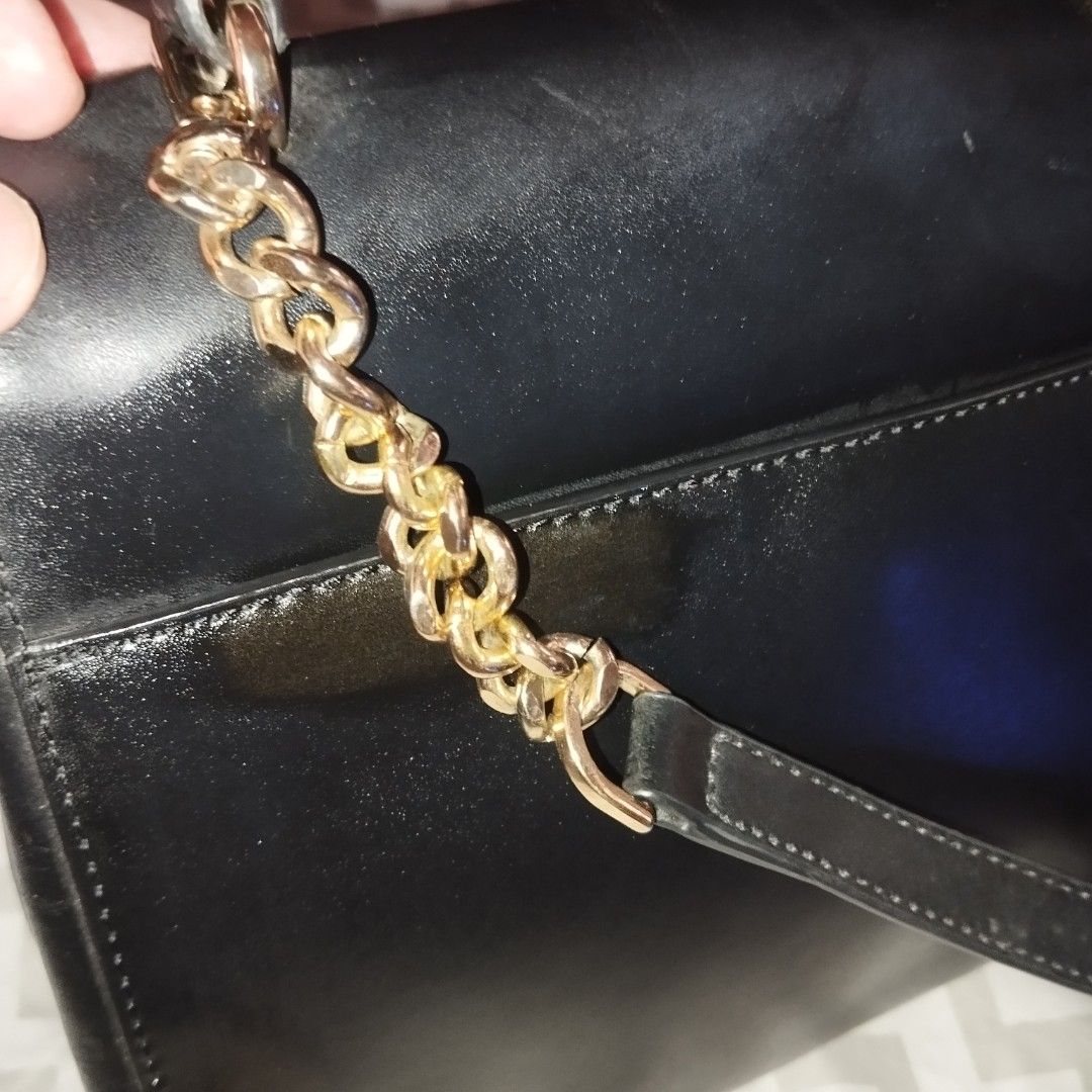 Michael Kors Black Leather Handbag with Gold Hardware (Category: Cross-body Bags) located in Manila. Submitted by lene48 (Listing ID 1470150676, Image 3). Description: - Brand: Michael Kors - Material: Premium black leather with gold-tone hardware - Design: Front flap with metallic MK logo and protective base feet - Strap: Combined chain and leather shoulder strap - Interior: MK logo-patterned lining, one zipped pocket, one slip pocket, and inter