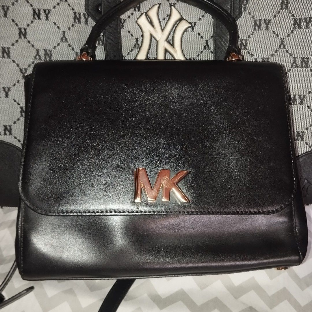 Michael Kors Black Leather Handbag with Gold Hardware (Category: Cross-body Bags) located in Manila. Submitted by lene48 (Listing ID 1470150676, Image 1). Description: - Brand: Michael Kors - Material: Premium black leather with gold-tone hardware - Design: Front flap with metallic MK logo and protective base feet - Strap: Combined chain and leather shoulder strap - Interior: MK logo-patterned lining, one zipped pocket, one slip pocket, and inter