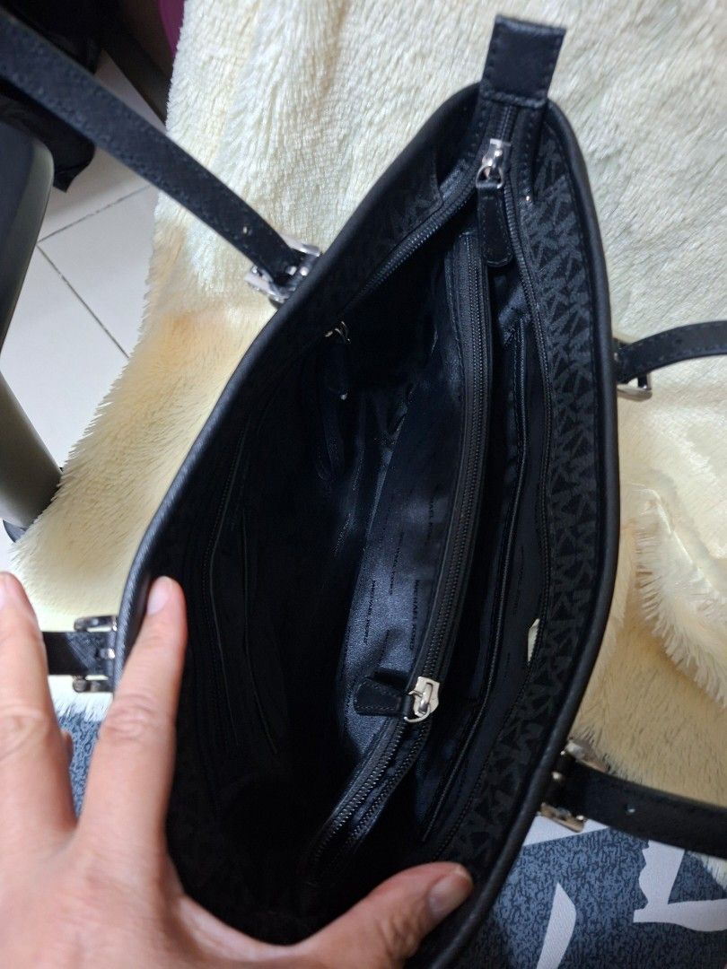 Michael Kors Black Monogram Tote Bag (Category: Tote Bags) located in Manila. Submitted by yanakolekzione (Listing ID 1470321959, Image 3). Description: - Pwede sa maselan super mukhang brand new Authentic black Michael Kors tote with all-over MK monogram pattern - Structured design featuring silver-tone hardware - Convenient front slip pocket with snap button closure - Secure main zip compartment with lined interior, zip pocket, and slip slots -