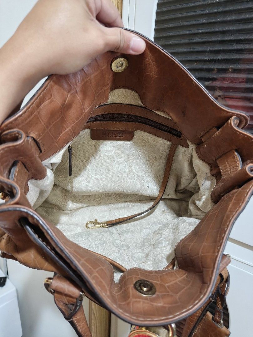 Michael Kors Brown Crocodile Embossed Leather Satchel (Category: Luxury Bags & Wallets) located in Manila. Submitted by luxph2 (Listing ID 1470219620, Image 3). Description: - Brand: Michael Kors - Material: Tan brown faux crocodile leather - Hardware: Gold-tone with protective bottom feet - Features: Dual top handles, adjustable crossbody strap, and front hanging lock charm - Interior: Zip pocket and clean fabric logo lining - Condition: Well ma