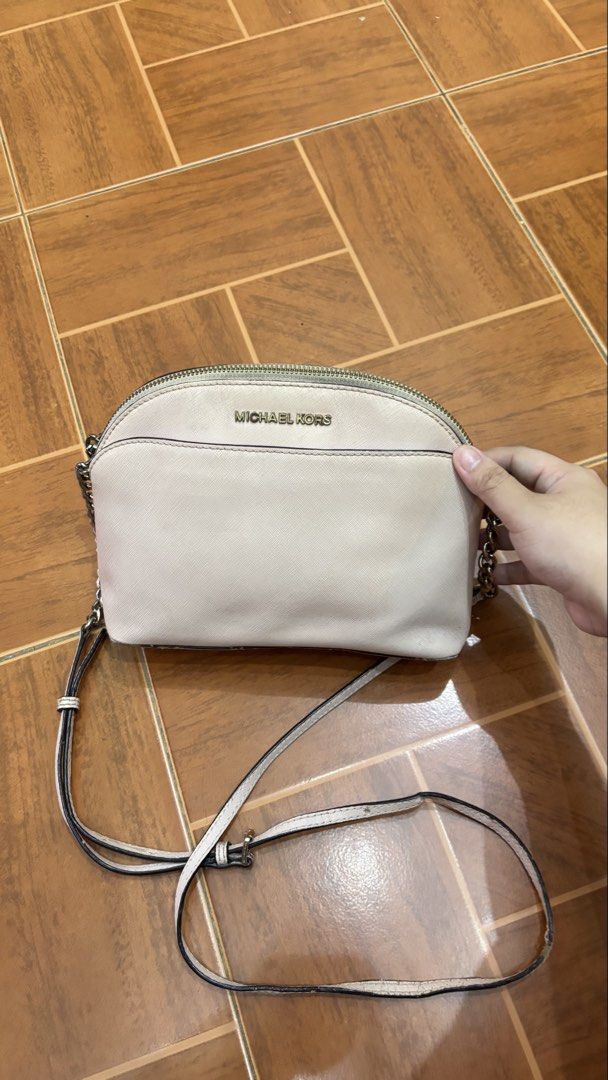Michael Kors Dome Crossbody Bag (Category: Cross-body Bags) located in Manila. Submitted by calliope777 (Listing ID 1470215475, Image 1). Description: - Brand: Michael Kors - Style: Dome Crossbody Bag - Color: Blush Pink - Material: Saffiano leather with gold-tone hardware - Closure: Zip top - Pockets: Convenient front slip pocket - Strap: Metal chain detail with adjustable long leather strap - Condition: Compact size for daily essentials, with m