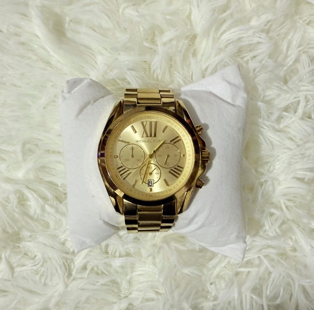 Michael Kors Gold Chronograph Watch (Category: Women's Watches) located in Caloocan City. Submitted by buritomma (Listing ID 1470157611, Image 1). Description: - Brand: Michael Kors For Men - Color: Polished Gold - Movement: Battery-powered analog - Face: Classic round dial with Roman numerals - Features: 3 sub-dials and date display at the bottom - Strap: Durable metal link bracelet - Versatility: Great for daily wear or dressing up for special 