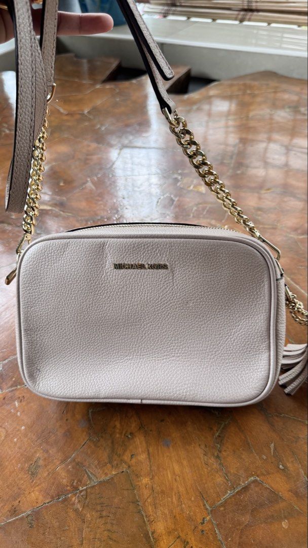 Michael Kors Leather Crossbody Bag (Category: Cross-body Bags) located in Tagbilaran City. Submitted by Bunnybebu (Listing ID 1470295527, Image 1). Description: - Brand: Michael Kors - Material: Pebbled leather in light pink - Hardware: Gold-tone with chain accents and matching leather tassel - Strap: Includes adjustable leather shoulder strap - Interior: MK logo fabric lining with slip and zipper pockets - Condition: Good, with a minor blue ink 