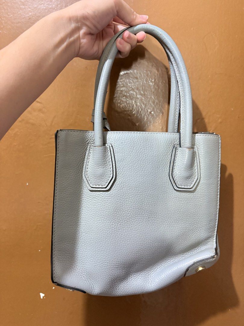 Michael Kors Light Blue Leather Satchel Handbag (Category: Luxury Bags & Wallets) located in Mandaluyong City. Submitted by gentle.segoviajam (Listing ID 1470264290, Image 2). Description: - Brand: Michael Kors - Material: Light blue pebbled leather with gold-tone hardware - Straps: Top handles and detachable crossbody strap - Features: Secure zip-top closure, internal zip pocket, and protective bottom metal feet - Condition: Clean interior linin