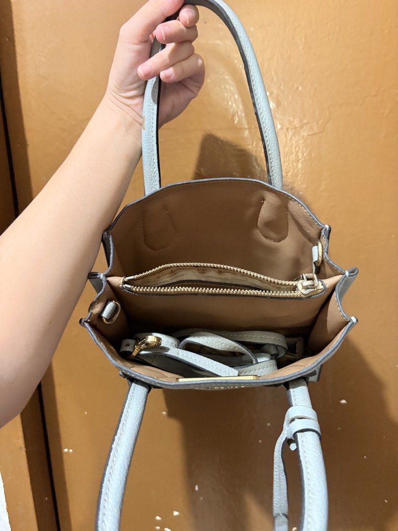 Michael Kors Light Blue Leather Satchel Handbag (Category: Luxury Bags & Wallets) located in Mandaluyong City. Submitted by gentle.segoviajam (Listing ID 1470264290, Image 3). Description: - Brand: Michael Kors - Material: Light blue pebbled leather with gold-tone hardware - Straps: Top handles and detachable crossbody strap - Features: Secure zip-top closure, internal zip pocket, and protective bottom metal feet - Condition: Clean interior linin