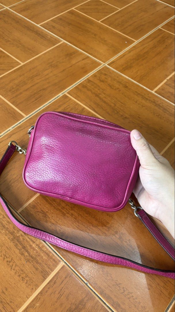 Michael Kors Pink Leather Crossbody Bag (Category: Cross-body Bags) located in Manila. Submitted by calliope777 (Listing ID 1470215599, Image 3). Description: - Brand: Michael Kors - Material: Bright pink pebbled leather - Hardware: Gold MK logo (shows minor wear) - Closure: Zip top - Interior: Signature fabric lining with 1 slip pocket and card slots - Strap: Adjustable leather crossbody strap - Condition: Minor wear on edges and hardware.