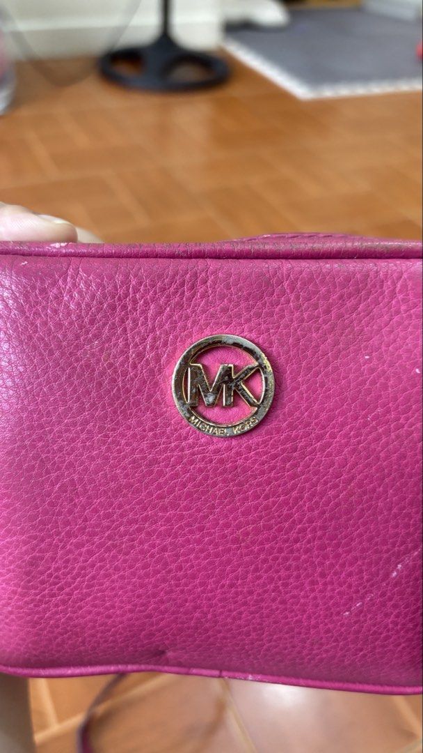 Michael Kors Pink Leather Crossbody Bag (Category: Cross-body Bags) located in Manila. Submitted by calliope777 (Listing ID 1470215599, Image 1). Description: - Brand: Michael Kors - Material: Bright pink pebbled leather - Hardware: Gold MK logo (shows minor wear) - Closure: Zip top - Interior: Signature fabric lining with 1 slip pocket and card slots - Strap: Adjustable leather crossbody strap - Condition: Minor wear on edges and hardware.