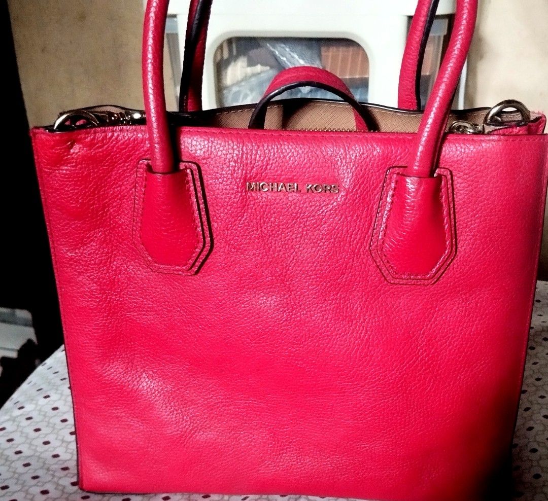 Michael Kors Red Leather Tote Bag (Category: Tote Bags) located in Manila. Submitted by lene48 (Listing ID 1470283405, Image 2). Description: Bright red pebbled leather tote bag from Michael Kors. Gold tone hardware and lettering logo on the front. Double top handles plus a detachable matching strap. Protective metal feet on the bottom base. Zip top closure. Clean inside lining. Great size for daily use, fits phones, keys, and a small wallet easi