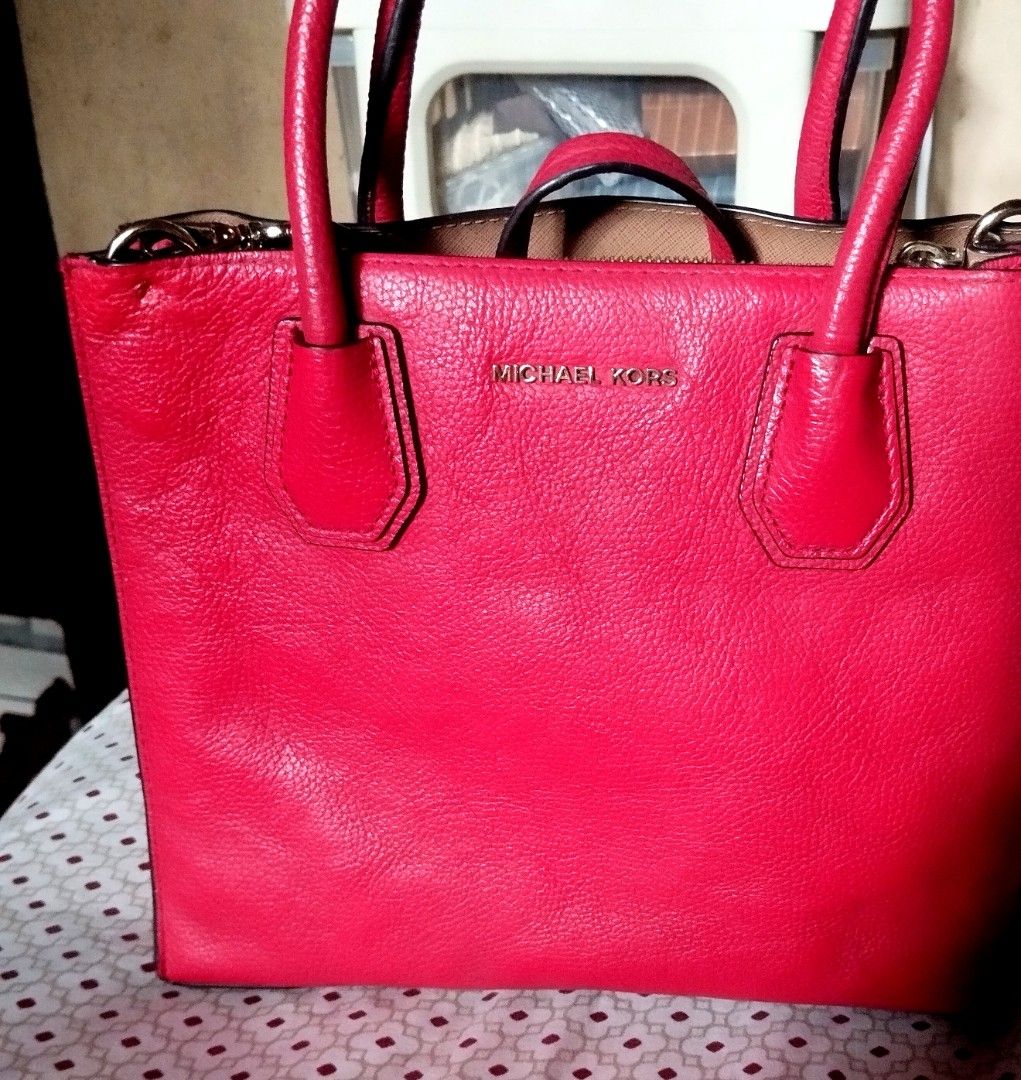Michael Kors Red Leather Tote Bag (Category: Tote Bags) located in Manila. Submitted by lene48 (Listing ID 1470283405, Image 1). Description: Bright red pebbled leather tote bag from Michael Kors. Gold tone hardware and lettering logo on the front. Double top handles plus a detachable matching strap. Protective metal feet on the bottom base. Zip top closure. Clean inside lining. Great size for daily use, fits phones, keys, and a small wallet easi