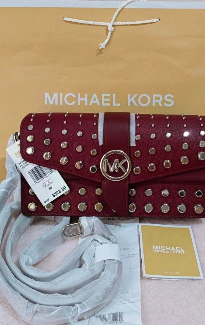Michael Kors Studded Medium Convertible Leather Handbag Maroon (Category: Luxury Bags & Wallets) located in Quezon City. Submitted by shinereign (Listing ID 1470212995, Image 1). Description: - Authentic Michael Kors Saffiano leather bag in a rich maroon color - Edgy silver stud detailing with a chic circular MK logo snap closure - Versatile removable shoulder strap featuring a stylish chain-link accent - Organized interior with multiple compartm