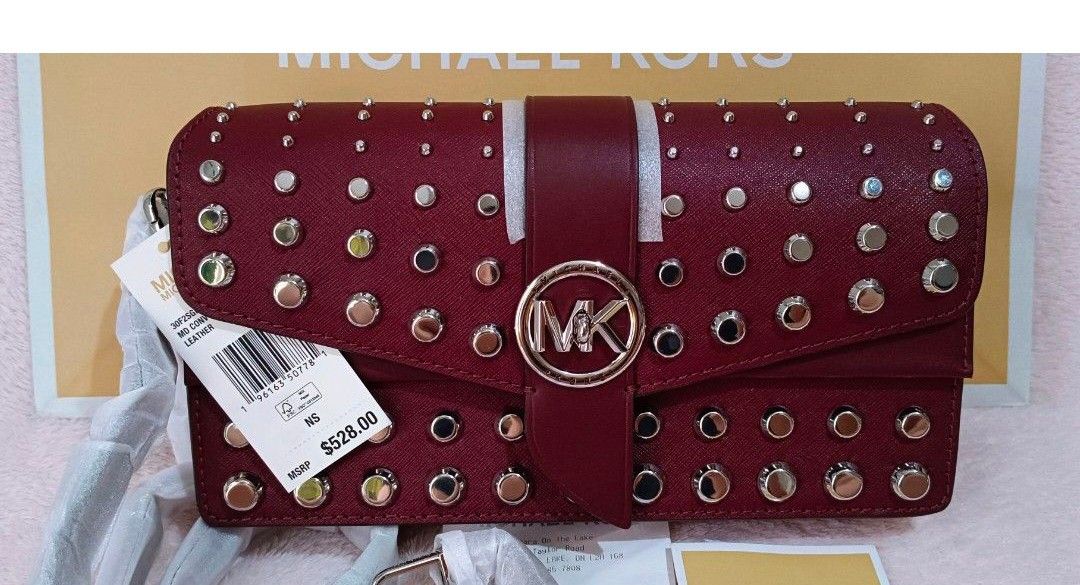 Michael Kors Studded Medium Convertible Leather Handbag Maroon (Category: Luxury Bags & Wallets) located in Quezon City. Submitted by shinereign (Listing ID 1470212995, Image 2). Description: - Authentic Michael Kors Saffiano leather bag in a rich maroon color - Edgy silver stud detailing with a chic circular MK logo snap closure - Versatile removable shoulder strap featuring a stylish chain-link accent - Organized interior with multiple compartm