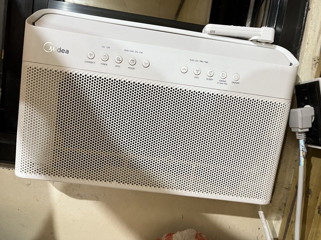 Midea Window Type Air Conditioner with Remote (Category: Air Conditioning and Heating) located in Manila. Submitted by curated.clutter12 (Listing ID 1470151634, Image 3). Description: - Brand: Midea - Type: Window type air conditioner - Color: Clean white with a modern grid design - Controls: Top touch control buttons and digital display remote (modes: Auto, Cool, Dry, Heat) - Extras: Includes matching remote control with a convenient wall mount 