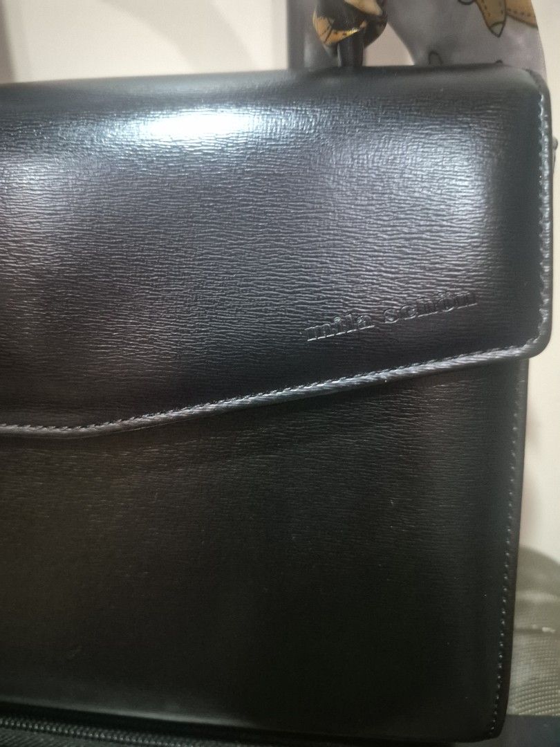 Mila Schon Black Leather Handbag (Category: Luxury Bags & Wallets) located in Iloilo. Submitted by gorgeoustatz (Listing ID 1470306579, Image 3). Description: - Brand: Mila Schon - Color: Classic Black - Material: Smooth grain leather - Closure: Flap with magnetic snap - Interior: Branded fabric lining with zip pocket - Details: Gold-tone hardware and embossed front logo - Style: Structured and elegant.