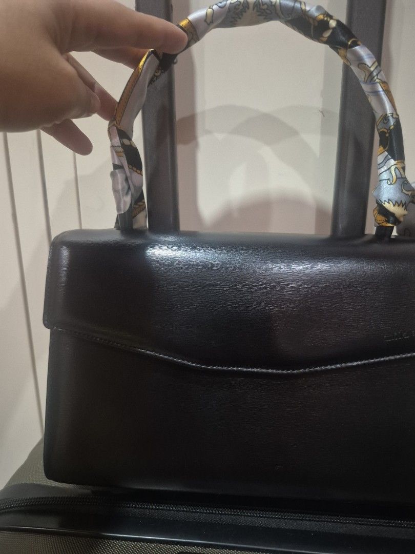 Mila Schon Black Leather Handbag (Category: Luxury Bags & Wallets) located in Iloilo. Submitted by gorgeoustatz (Listing ID 1470306579, Image 2). Description: - Brand: Mila Schon - Color: Classic Black - Material: Smooth grain leather - Closure: Flap with magnetic snap - Interior: Branded fabric lining with zip pocket - Details: Gold-tone hardware and embossed front logo - Style: Structured and elegant.