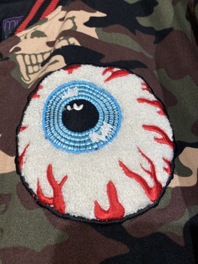 Mishka Keep Watch Camo Varsity Bomber Jacket Medium (Category: Coats, Jackets and Outerwear) located in Caloocan City. Submitted by camarcenin42067 (Listing ID 1470283112, Image 3). Description: - Brand: Mishka (Brooklyn, NY streetwear) - Style: Varsity bomber jacket in camo print - Size: Medium - Details: Iconic embroidered Keep Watch eyeball patch on chest, large Mishka text embroidery on back shoulders - Interior: Warm quilted black lining - C