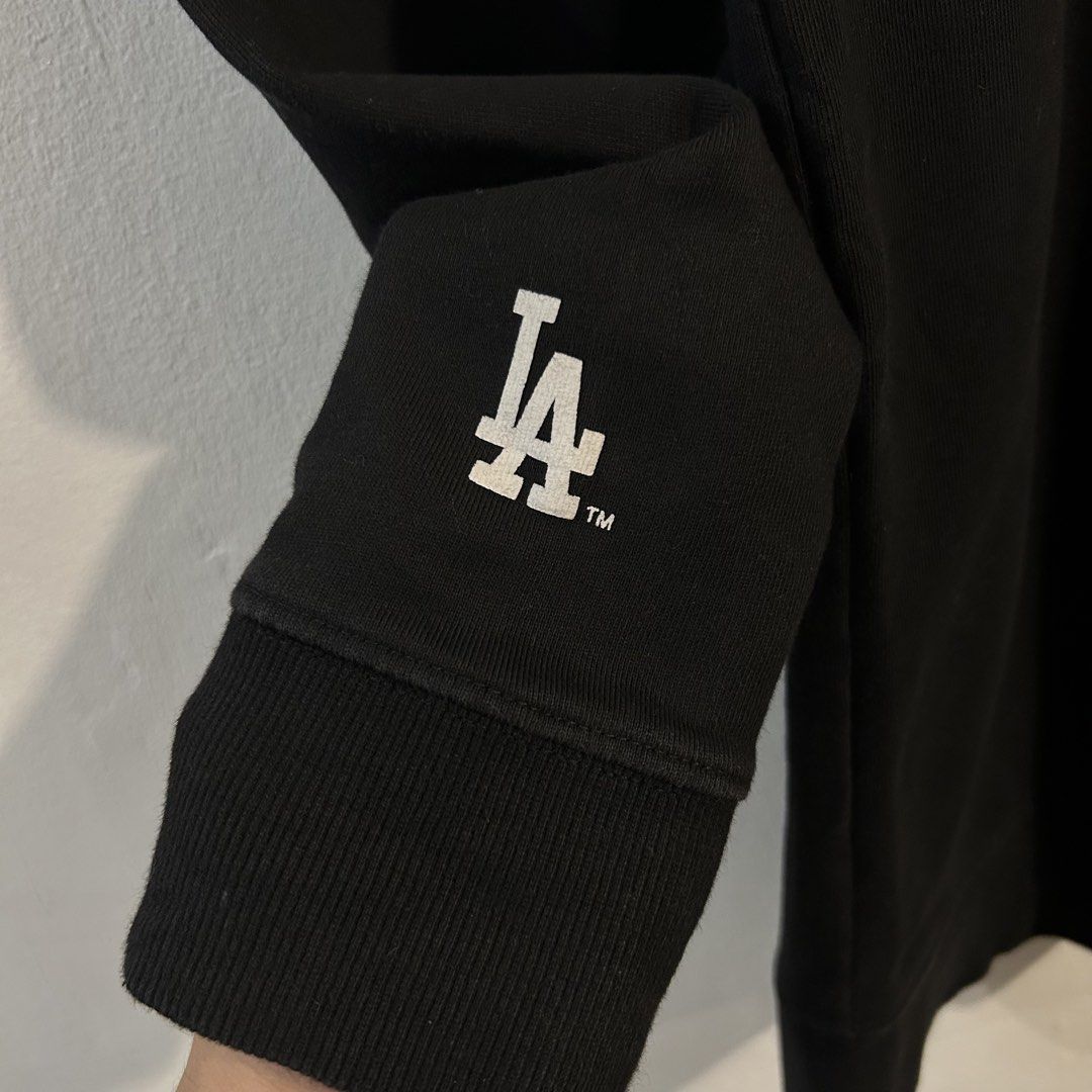 MLB Los Angeles Dodgers Black Graphic Sweatshirt (Category: Coats, Jackets and Outerwear) located in Manila. Submitted by jakes_thrift_shop (Listing ID 1470310970, Image 3). Description: - Authentic MLB Los Angeles Dodgers black sweatshirt - Small embroidered LA logo on the chest and large graphic print on the back - Cozy soft fleece interior for extra warmth - Official MLB branding tape inside the neckline - Team logo patch detail near the wrist