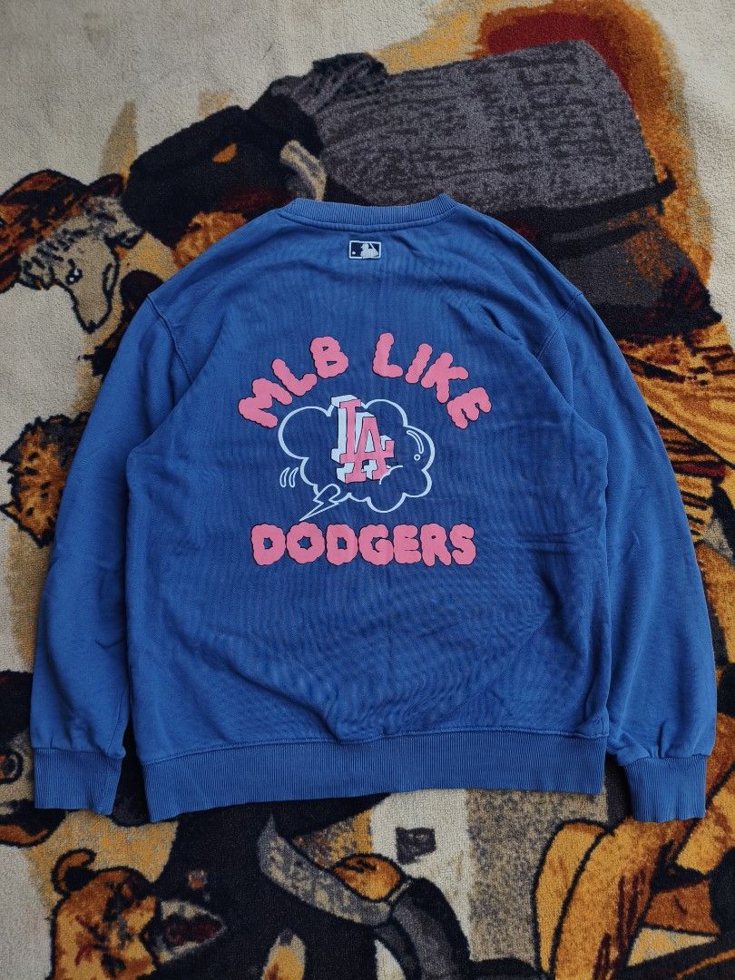 MLB Los Angeles Dodgers Blue Sweatshirt (Category: Coats, Jackets and Outerwear) located in Davao. Submitted by simonandre53791 (Listing ID 1470252968, Image 1). Description: - Authentic blue MLB Los Angeles Dodgers sweatshirt - Eye-catching pink and white LA graphics on front, sleeve, and back - Features stylish 'MLB LIKE DODGERS' lettering - Comfortable ribbed collar, cuffs, and hem - Comes with original MLB neck tag attached.