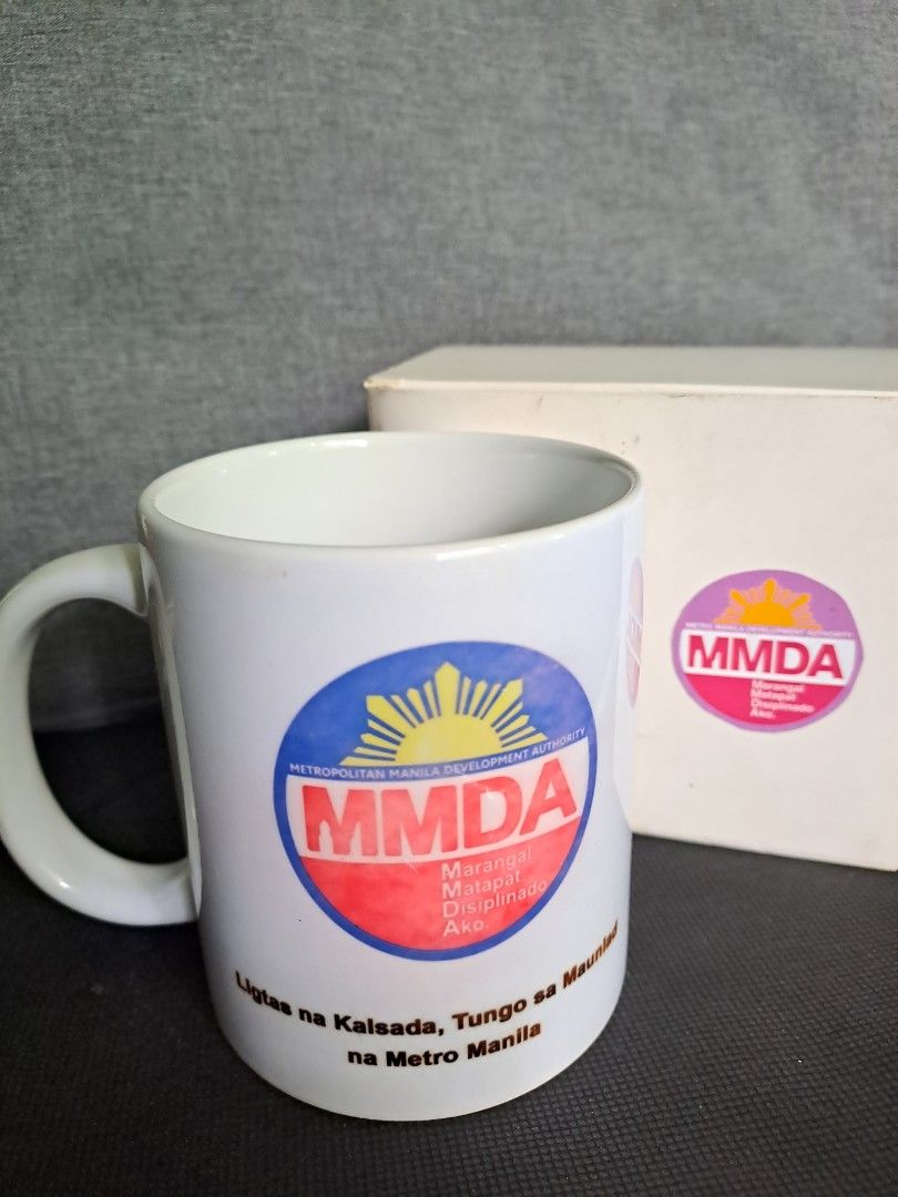 MMDA Mug with Box (Category: Coffee & Tea Tableware) located in Quezon City. Submitted by ph_araoh (Listing ID 1470173397, Image 1). Description: - Official souvenir from the Metro Manila Road Safety Summit 2025 - with MMDA logo - Standard coffee cup size with a smooth glazed ceramic finish - with original box with and sticker * * * * * Courier delivery available P75 shipping within Metro Manila NO COD. Payment first via InstaPay bank transfer Sh
