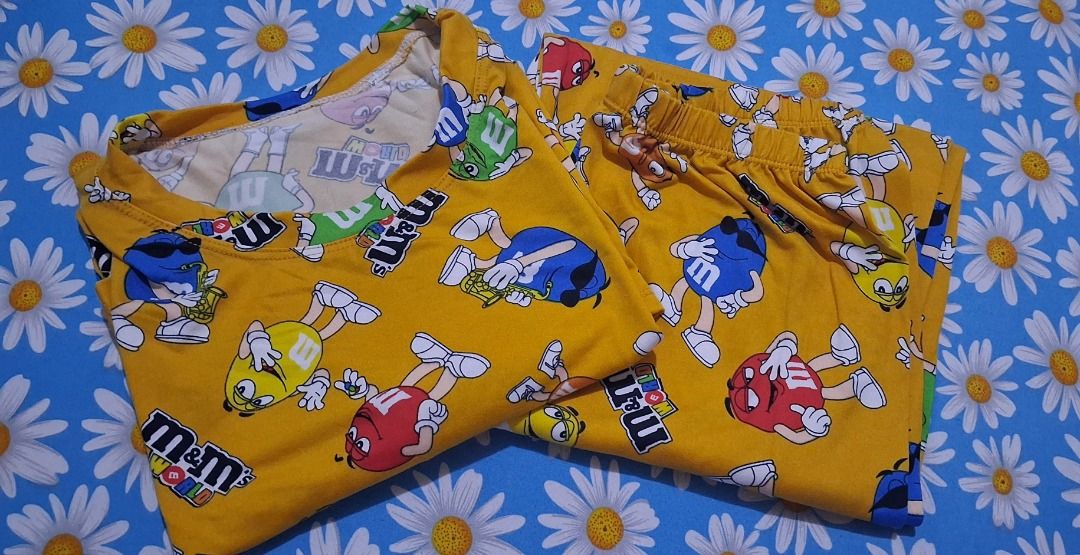 M&M's Character Print Pajama Set Two Colors Available (Category: Undergarments & Loungewear) located in Manila. Submitted by katkween23 (Listing ID 1470172696, Image 3). Description: - Fun M&M character print lounge sets - Includes short sleeve top and matching bottoms - Soft and cozy fabric with all-over cartoon candy graphics - Perfect for sleeping or lazy days at home - Available in 2 vibrant colors: Bright Blue and Mustard Yellow - Buy one or