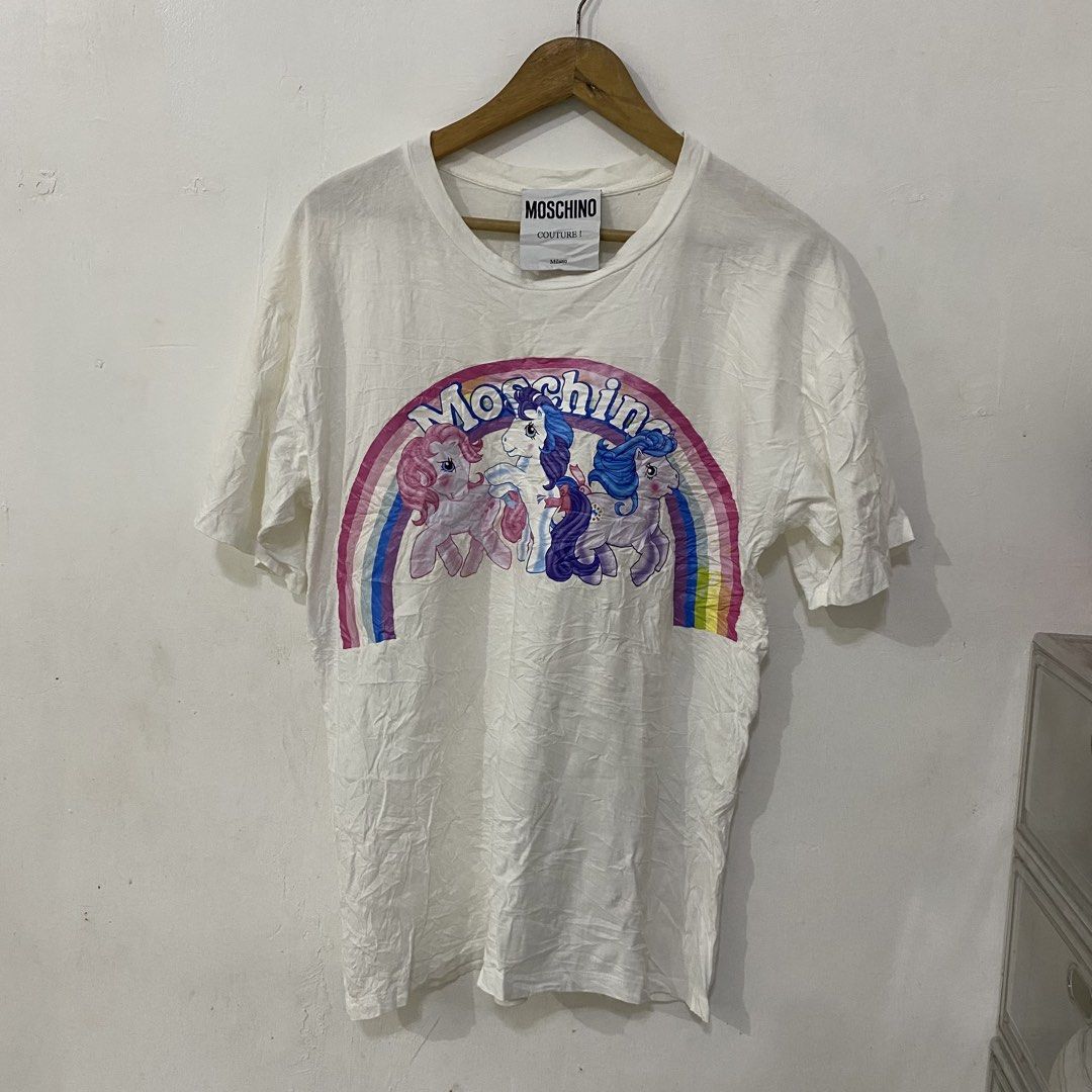 Moschino Unicorn Logo Tshirt (Category: Luxury Apparel) located in Las Pinas. Submitted by declutter_thing69 (Listing ID 1470185882, Image 1). Description: Moschino Unicorn Logo Tshirt Small Good condish width 19 inches length 28 inches shoulder 21 inches sleeve 7.5 inches.