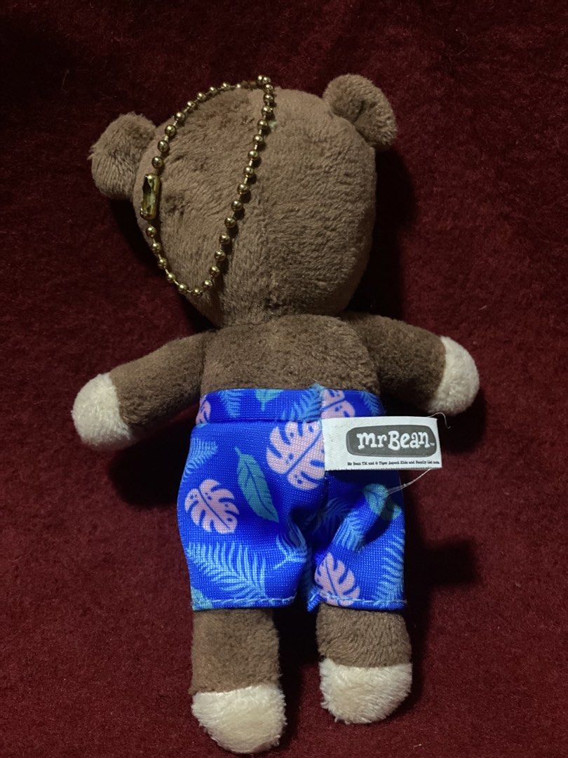 Mr Bean Teddy Bear Plush Keychain with Summer Shorts (Category: Plushies & Soft Toys) located in Manila. Submitted by kuya_moto (Listing ID 1470330521, Image 2). Description: - Official Mr. Bean merchandise featuring the iconic brown teddy bear - Wears stylish blue Hawaiian print swim shorts with a white drawstring and stitched tag - Soft fabric body complete with cream-colored paws and embroidered facial features - Equipped with a gold-toned bal