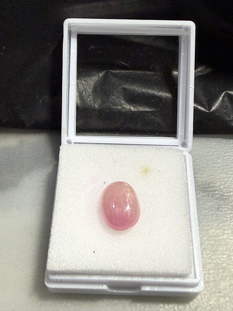 Natural Ruby (Category: Jewelry) located in Singapore. Submitted by ranosky76 (Listing ID 1470306800, Image 1). Description: - Type: Natural Ruby cabochon 9.15ct, diameter 13.5mmx10mmx5.7mm - Shape & Finish: Oval shape with a smooth, glossy surface - Color: Soft pink hue throughout - Condition: Clean polish with minimal surface marks - Ideal For: Custom jewelry setting or crystal collection - Note: Loose stone, shown on fingers for scale.