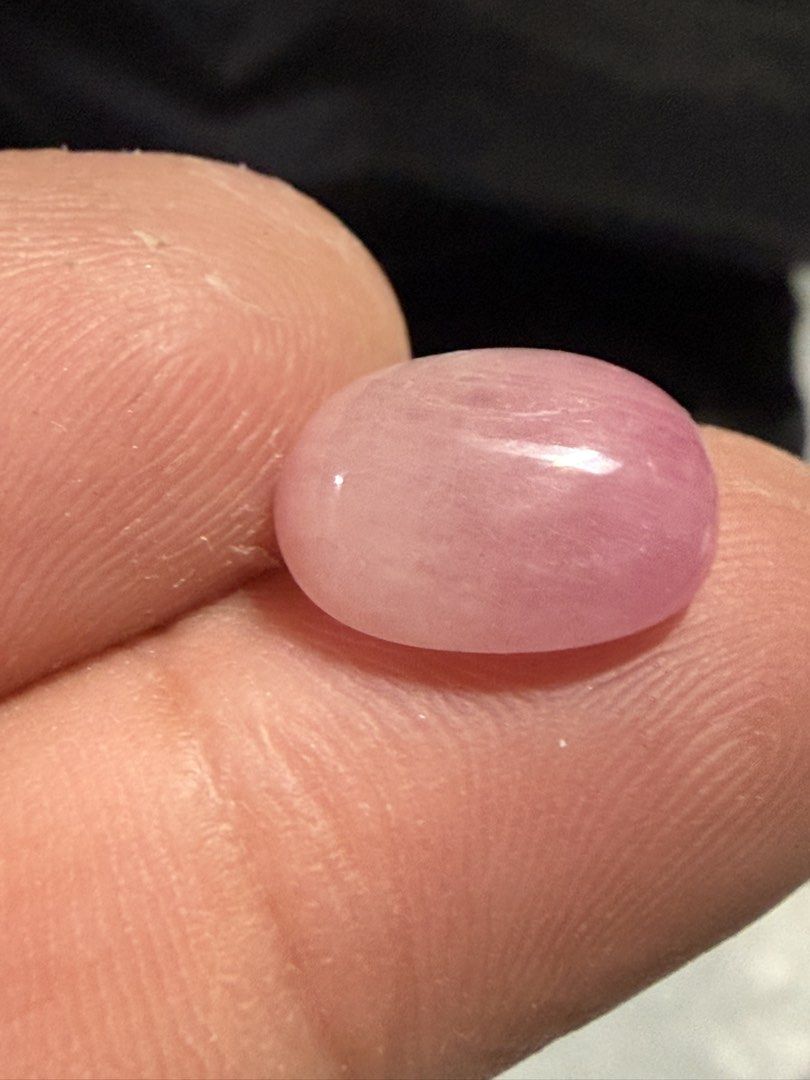 Natural Ruby (Category: Jewelry) located in Singapore. Submitted by ranosky76 (Listing ID 1470306800, Image 4). Description: - Type: Natural Ruby cabochon 9.15ct, diameter 13.5mmx10mmx5.7mm - Shape & Finish: Oval shape with a smooth, glossy surface - Color: Soft pink hue throughout - Condition: Clean polish with minimal surface marks - Ideal For: Custom jewelry setting or crystal collection - Note: Loose stone, shown on fingers for scale.