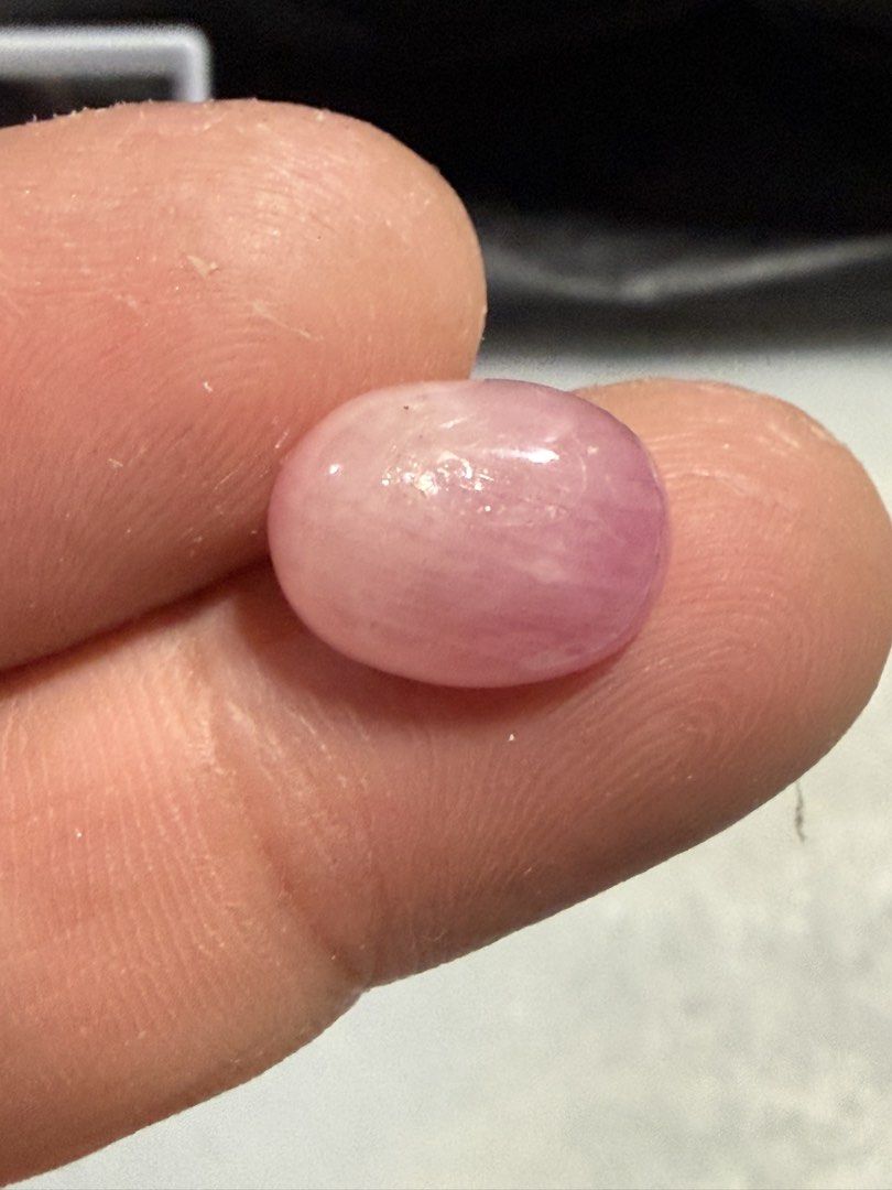 Natural Ruby (Category: Jewelry) located in Singapore. Submitted by ranosky76 (Listing ID 1470306800, Image 2). Description: - Type: Natural Ruby cabochon 9.15ct, diameter 13.5mmx10mmx5.7mm - Shape & Finish: Oval shape with a smooth, glossy surface - Color: Soft pink hue throughout - Condition: Clean polish with minimal surface marks - Ideal For: Custom jewelry setting or crystal collection - Note: Loose stone, shown on fingers for scale.