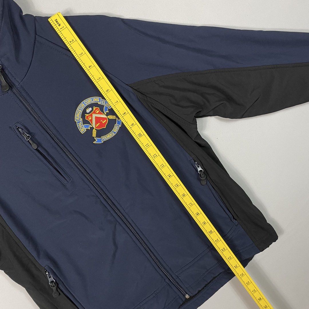 Navy Blue Athletic Sport-Casual Softshell Jacket Unisex (Category: Coats, Jackets and Outerwear) located in Norzagaray. Submitted by sevenjscloset (Listing ID 1470249715, Image 3). Description: - Color/Design: Navy blue with black panels and Royal Kingston Curling Club embroidery - Size: Fit small to medium - Features: Full zip closure, side zip pockets, and an upper chest zip pocket - Measurements: 24.5 inches (length) x 18.5 inches (width) - Co
