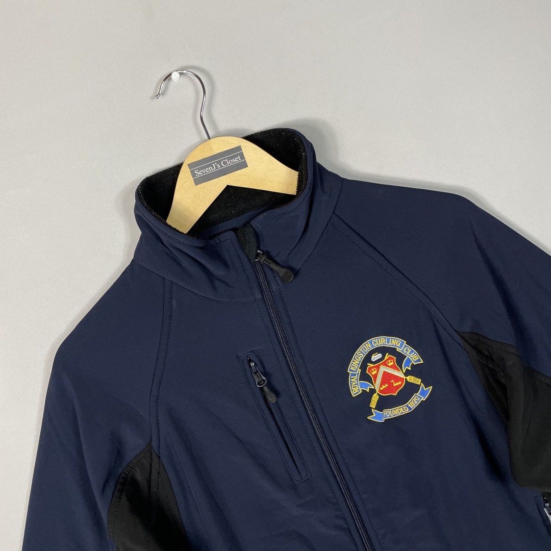 Navy Blue Athletic Sport-Casual Softshell Jacket Unisex (Category: Coats, Jackets and Outerwear) located in Norzagaray. Submitted by sevenjscloset (Listing ID 1470249715, Image 2). Description: - Color/Design: Navy blue with black panels and Royal Kingston Curling Club embroidery - Size: Fit small to medium - Features: Full zip closure, side zip pockets, and an upper chest zip pocket - Measurements: 24.5 inches (length) x 18.5 inches (width) - Co