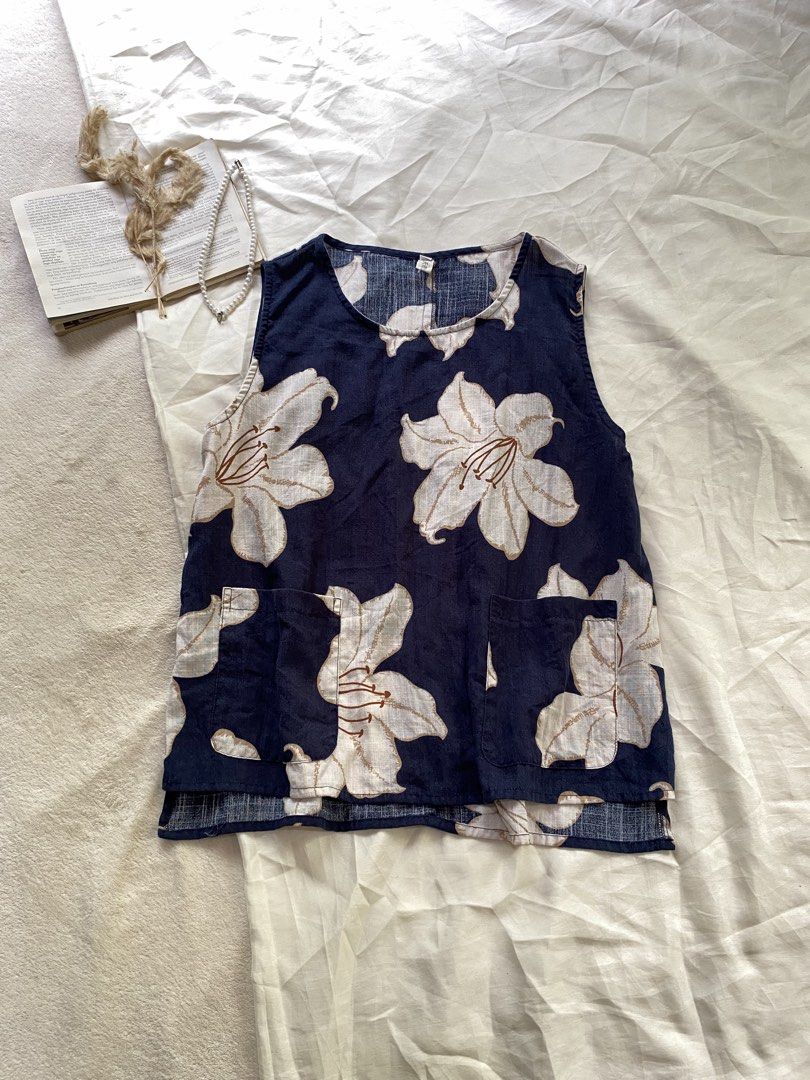 Navy Floral Sleeveless Top with Front Pockets Medium 37 (Category: Sleeveless) located in Poro. Submitted by joyceyuu (Listing ID 1470167591, Image 1). Description: - Color & Pattern: Navy blue with an all-over large white floral print - Design: Sleeveless, round neckline, and loose fit for ultimate comfort - Features: Two functional front pockets near the hem - Hemline: Trendy high-low cut with split sides - Fabric: Lightweight and breathable, i