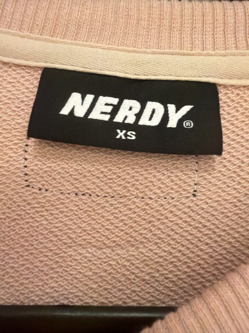 Nerdy pullover (Category: Longsleeves) located in Singapore. Submitted by sl_3715 (Listing ID 1470247799, Image 2). Description: - Brand: NERDY - Item: Pullover / Sweatshirt - Color: Pink with white sleeve taping and chest logo - Size: XS (100% Cotton) - Condition: Excellent pre-loved condition - Features: Soft interior, stylish streetwear aesthetic .