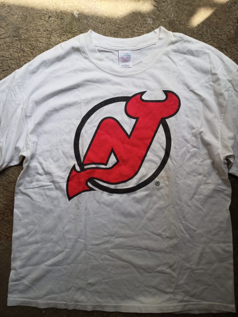 New Jersey Devils NHL Tee (Category: Tshirts & Polo Shirts ) located in Manila. Submitted by tuazonjohn12680 (Listing ID 1470182568, Image 2). Description: Tag: Gildan Heavy Weight Cotton XL Size: XL on tag (fits L-XL) if needed Color: White Condition: 8.5/10 Good vintage condition Details: - Official NHL Licensed (with ®) - Big Logo Print - Early 2000s Y2K Tag - Championship era (Devils won Stanley Cup 2000 & 2003) - No major holes/stains - need