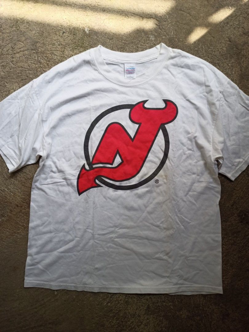 New Jersey Devils NHL Tee (Category: Tshirts & Polo Shirts ) located in Manila. Submitted by tuazonjohn12680 (Listing ID 1470182568, Image 1). Description: Tag: Gildan Heavy Weight Cotton XL Size: XL on tag (fits L-XL) if needed Color: White Condition: 8.5/10 Good vintage condition Details: - Official NHL Licensed (with ®) - Big Logo Print - Early 2000s Y2K Tag - Championship era (Devils won Stanley Cup 2000 & 2003) - No major holes/stains - need