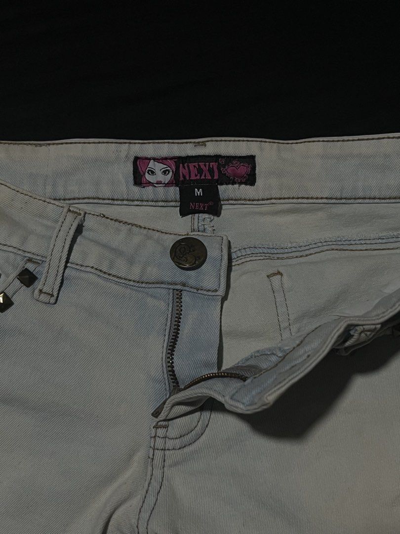 NEXT Light Wash Studded Denim Shorts Size M (Category: Shorts) located in Manila. Submitted by y2kcloset_ (Listing ID 1470184716, Image 3). Description: - Brand: NEXT - Size: Medium - Wash: Light wash denim - Fit: Mid-rise with button and zip fly closure - Details: Brass studs on front, back pockets, and cuffs with rolled hems - Style: Y2K, casual festival vibe.