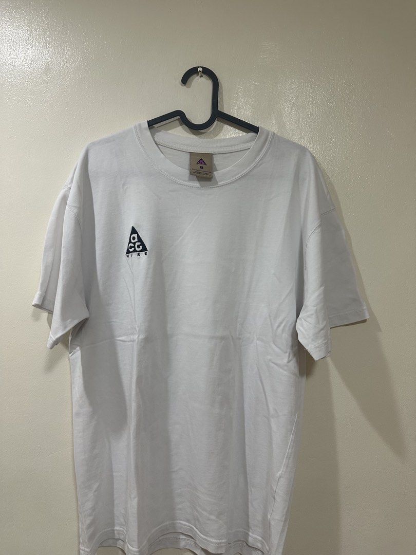 Nike ACG White T-Shirt (Category: Tshirts & Polo Shirts ) located in Manila. Submitted by rarewhale-91927a (Listing ID 1470215743, Image 1). Description: - Brand: Nike ACG - Color: White - Size: Small (Made in Vietnam) - Design: Small embroidered triangle logo on chest, crew neck, short sleeves - Fit: Standard fit cotton tee - Condition: Clean overall with minimal signs of wear.