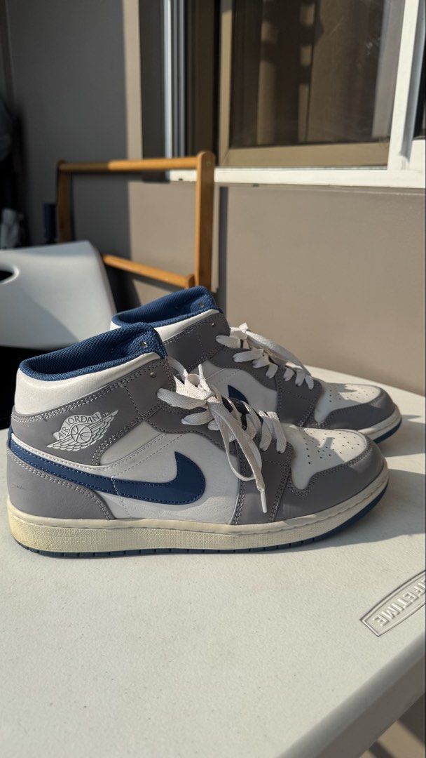 Nike Air Jordan 1 Mid Grey Blue White (Category: Sneakers) located in Makati City. Submitted by lsdnlldvr (Listing ID 1470214924, Image 3). Description: - Model: Mid-top Jordans - Colorway: Grey, white, and blue with blue mesh inner lining - Materials: Classic leather upper and signature swoosh - Details: Wings logo on collar and white laces - Condition: Clean shape with minimal wear on soles.