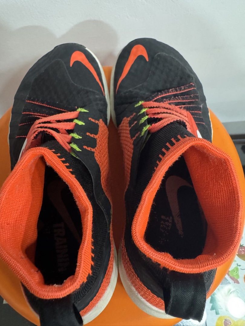 Nike Free Flyon Training Shoes Black Orange (Category: Sneakers) located in Valenzuela. Submitted by sofiasticated.decluttering (Listing ID 1470163126, Image 3). Description: - Brand: Nike Training Shoes - Colorway: Black with bright orange, neon green, and white accents - Design: High-top sockliner with Flywire lacing system and fabric heel pull tabs - Branding: Bright orange swoosh on the sides and toe box - Sole: White Free Flylon midsoles - C