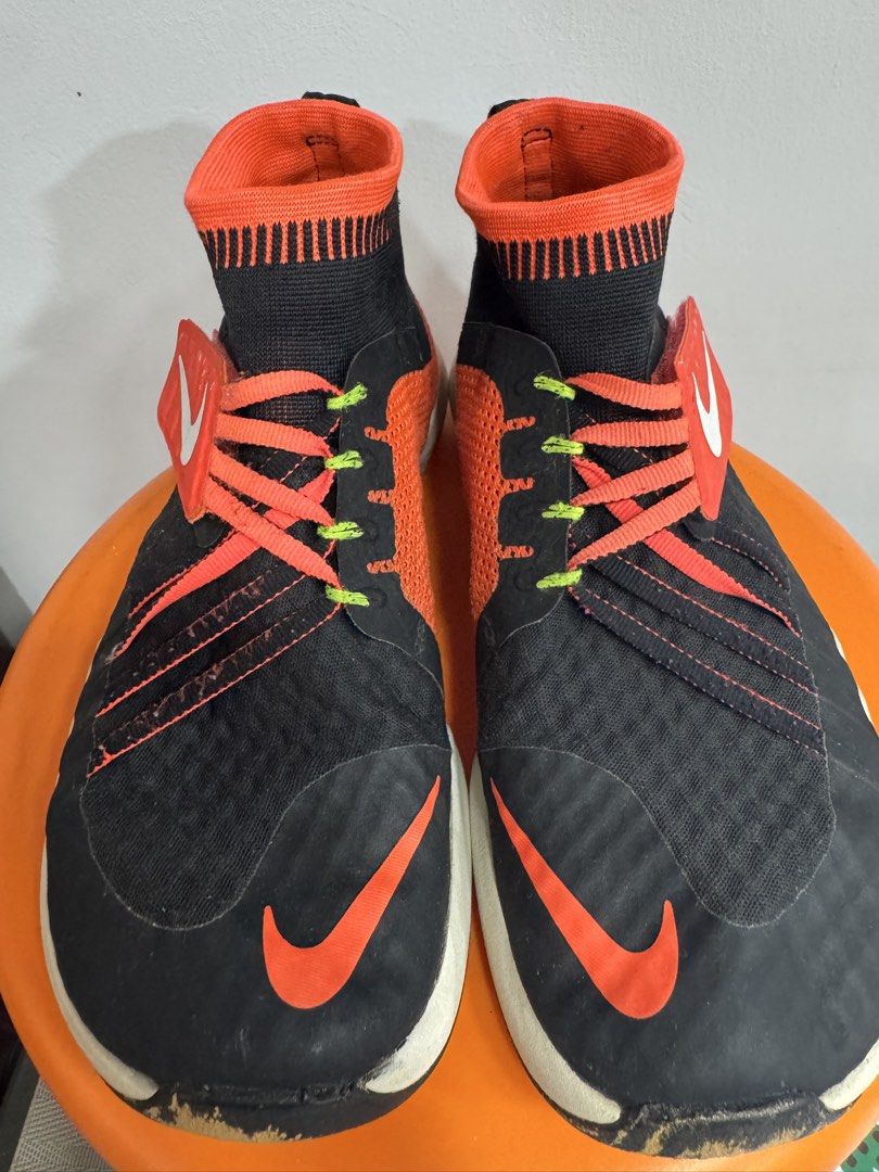 Nike Free Flyon Training Shoes Black Orange (Category: Sneakers) located in Valenzuela. Submitted by sofiasticated.decluttering (Listing ID 1470163126, Image 1). Description: - Brand: Nike Training Shoes - Colorway: Black with bright orange, neon green, and white accents - Design: High-top sockliner with Flywire lacing system and fabric heel pull tabs - Branding: Bright orange swoosh on the sides and toe box - Sole: White Free Flylon midsoles - C