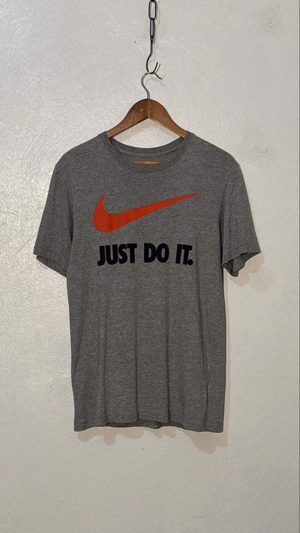 Nike Just Do It Grey T-shirt (Category: Tshirts & Polo Shirts ) located in Manila. Submitted by glano (Listing ID 1470299598, Image 1). Description: - Brand: Nike - Color: Grey with orange swoosh and black 'Just Do It' lettering - Size: Large (Regular fit) - Material: Soft and comfortable cotton blend - Details: Printed inner neck label with nikebetterworld.com - Ideal for: Everyday casual wear or workouts.