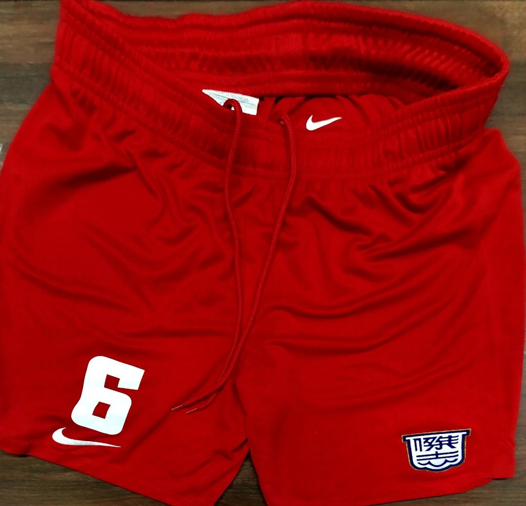 Nike Kitchee Kowloon Shorts Number 6 with Crest (Category: Shorts) located in Caloocan City. Submitted by safebear_4bdc70 (Listing ID 1470284266, Image 1). Description: Bright red Nike sports shorts with an elastic drawstring waistband. Large number 6 printed on the right leg above a small Swoosh logo. Embroidered crest patch on the left leg featuring blue and white Chinese characters inside a shield border. Lightweight polyester fabric. Clean st