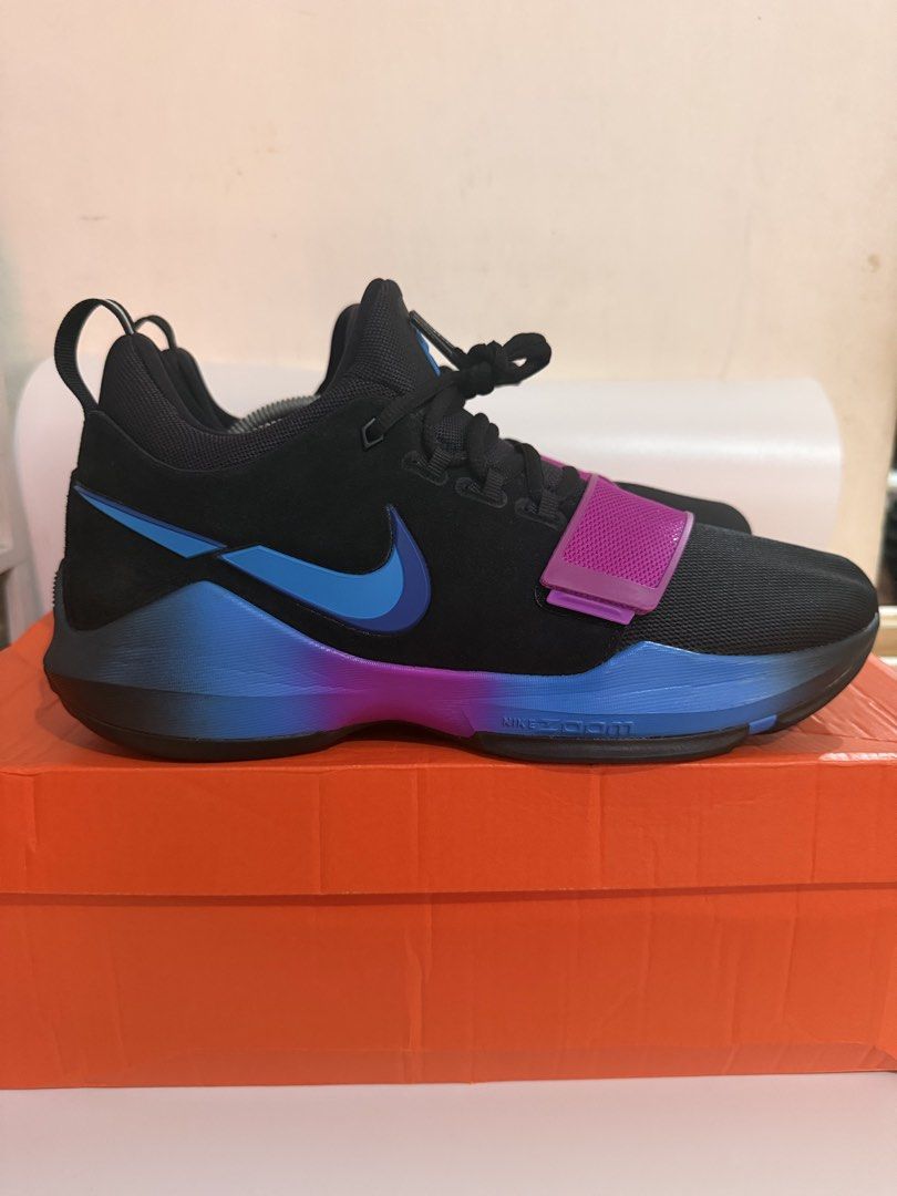 Nike PG 1 retro (Category: Sneakers) located in Pasay City. Submitted by ellianapenelope (Listing ID 1470206268, Image 3). Description: - Model: Nike PG 1 Signature Basketball Shoes - Colorway: Black with bright purple and blue accents - Support: Secure midfoot strap across the forefoot - Cushioning: Responsive Nike Zoom sole for comfort on and off the court - Details: Number 13 molded into the heel counter - Inclusions: Original orange Nike shoe