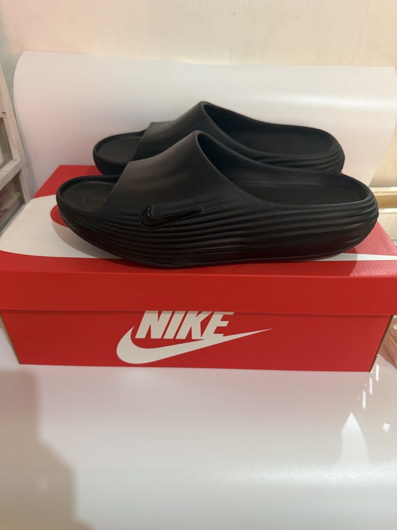Nike ReactX Rejuven8 Slide Black Size 10 (Category: Slippers & Slides) located in Pasay City. Submitted by ellianapenelope (Listing ID 1470206832, Image 1). Description: - Item: Nike ReactX Rejuven8 Slides - Color: Black - Size: Men's US 10 / Women's US 11 - Condition: Brand new with original red and white Nike box - Comfort: Highly cushioned footbed with signature ReactX branding - Traction: Wavy textured sole underneath for enhanced grip - Perf